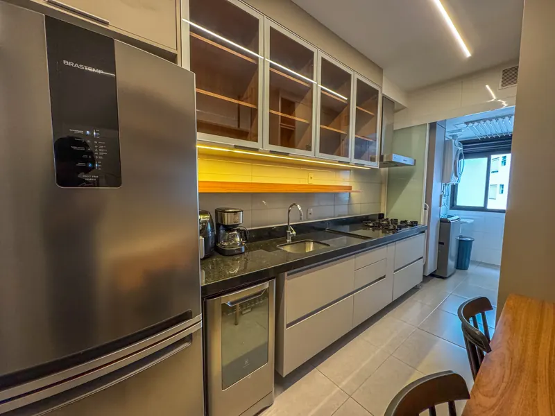 Cozinha planejada com eletrodomésticos em inox e iluminação embutida